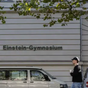 Schriftzug „Einstein-Gymnasium“ an einem Schulgebäude, davor ein Passant