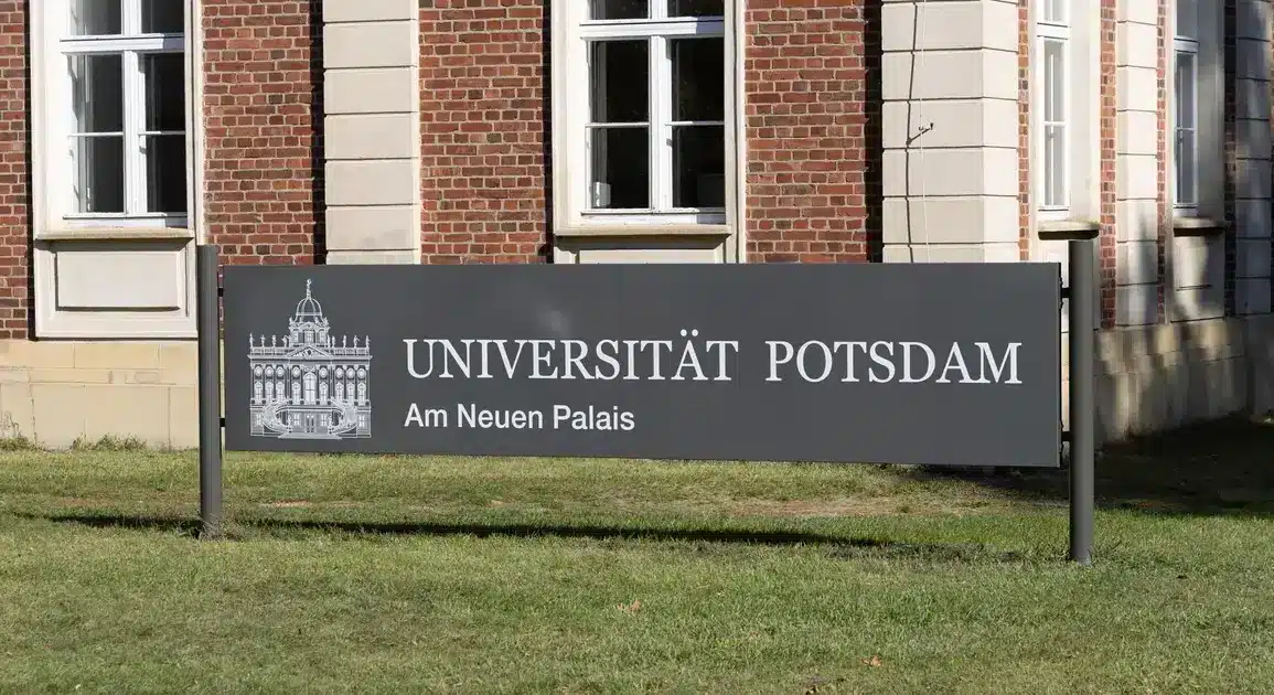 Schild „Universität Potsdam – Am Neuen Palais“ vor einem Backsteingebäude