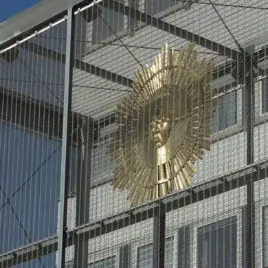 Goldene Sonne in einer Gitterkonstruktion vor blauem Himmel