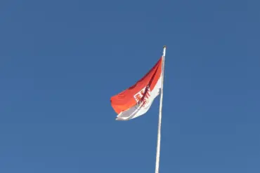 Brandenburger Landesflagge mit rotem Adler vor blauem Himmel
