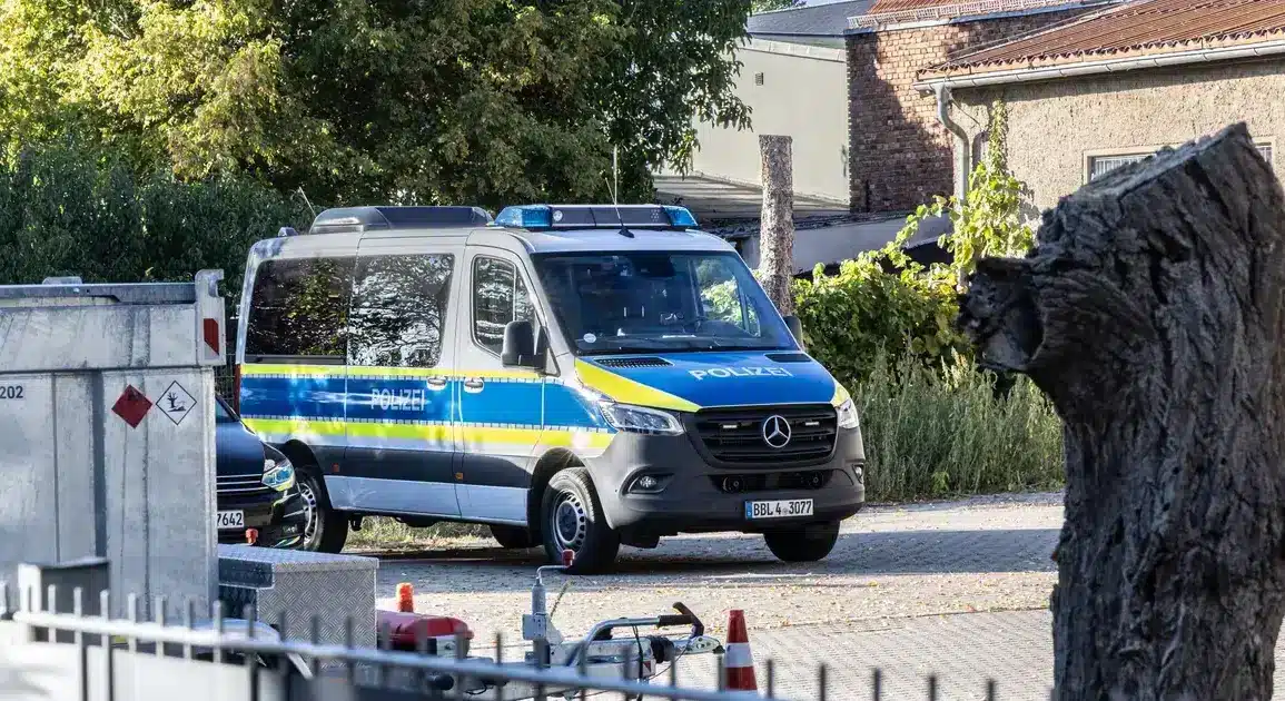 Polizei-Einsatzbus auf einem Hof hinter einem Zaun