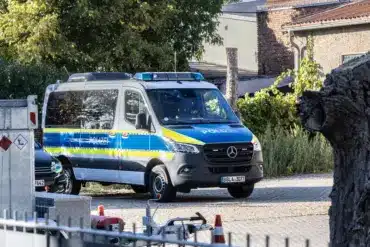 Polizei-Einsatzbus auf einem Hof hinter einem Zaun