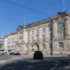 Wilhelminisches Gebäude an einer breiten Kreuzung mit Straßenbahngleisen