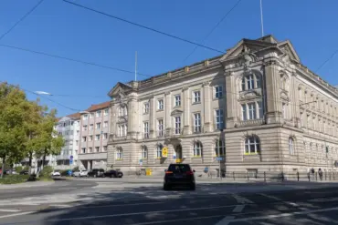 Wilhelminisches Gebäude an einer breiten Kreuzung mit Straßenbahngleisen