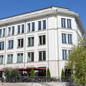 Weißes Geschäftshaus mit Restaurant-Terrasse und breiter Freitreppe
