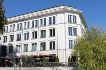 Weißes Geschäftshaus mit Restaurant-Terrasse und breiter Freitreppe
