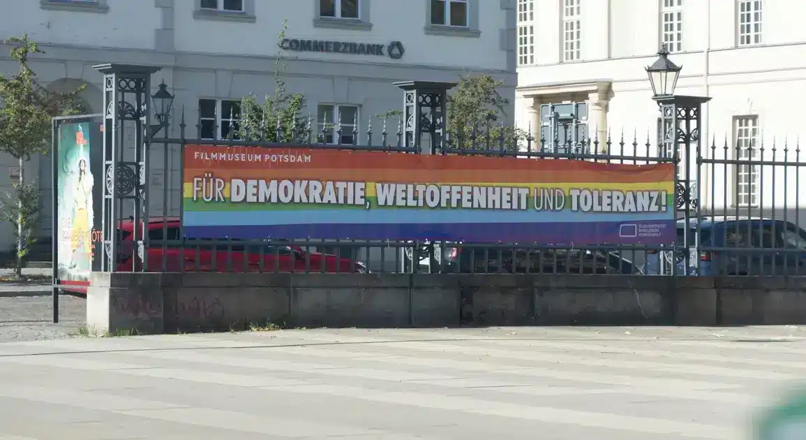Regenbogenbanner „Für Demokratie, Weltoffenheit und Toleranz!“ am Zaun des Filmmuseums