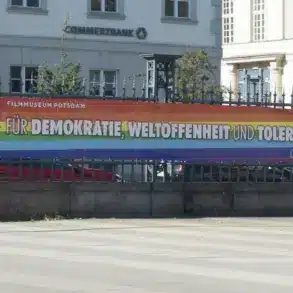 Regenbogenbanner „Für Demokratie, Weltoffenheit und Toleranz!“ am Zaun des Filmmuseums