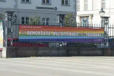 Regenbogenbanner „Für Demokratie, Weltoffenheit und Toleranz!“ am Zaun des Filmmuseums