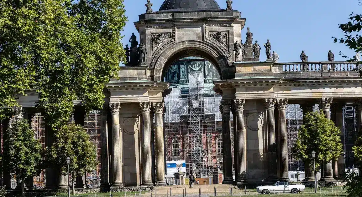 Triumphbogen der Kolonnade am Neuen Palais, dahinter ein eingerüstetes Gebäude