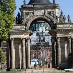 Triumphbogen der Kolonnade am Neuen Palais, dahinter ein eingerüstetes Gebäude