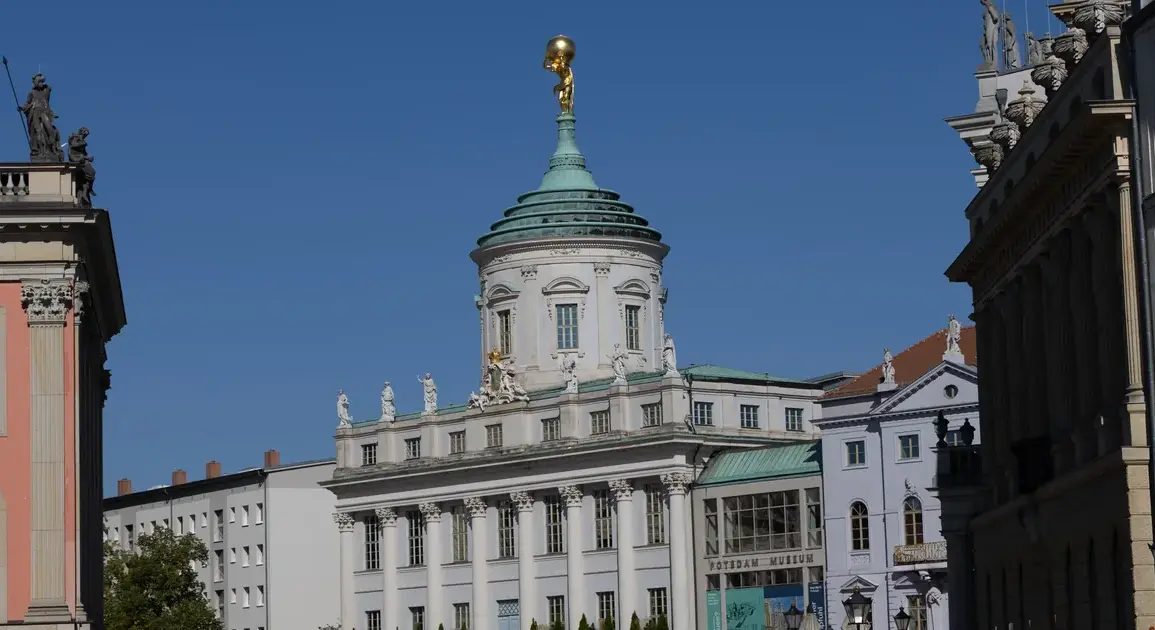 Blick auf das Alte Rathaus mit goldenem Atlas zwischen historischen Fassaden