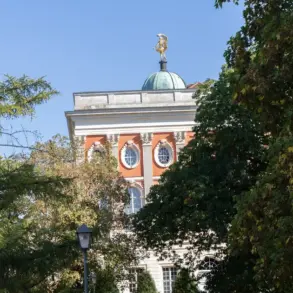 Kuppel und Fassade des Neuen Palais hinter hohen Bäumen
