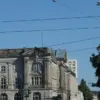 Historisches Verwaltungsgebäude an einer Kreuzung mit Straßenbahnoberleitungen