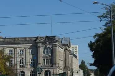Historisches Verwaltungsgebäude an einer Kreuzung mit Straßenbahnoberleitungen