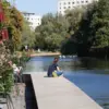 Frau sitzt am Ende eines Stegs an der Havel, daneben Café-Tische