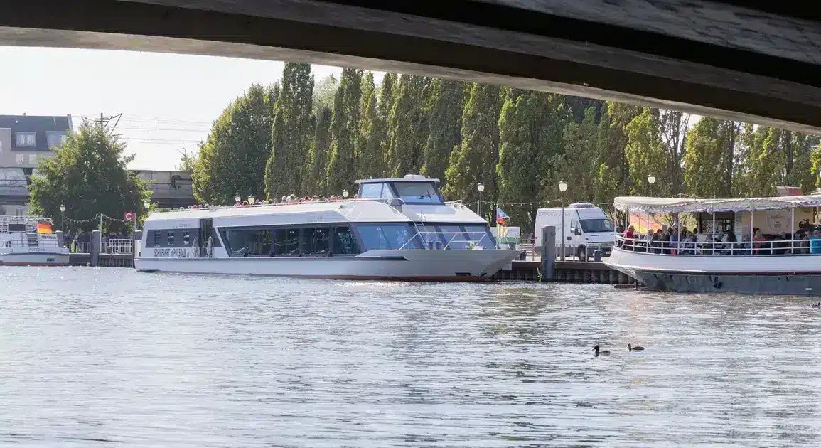 Ausflugsschiffe am Anleger auf der Havel, fotografiert unter einer Brücke hindurch