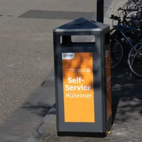 Orangefarbener Self-Service-Mülleimer der Stadtreinigung, dahinter abgestellte Fahrräder