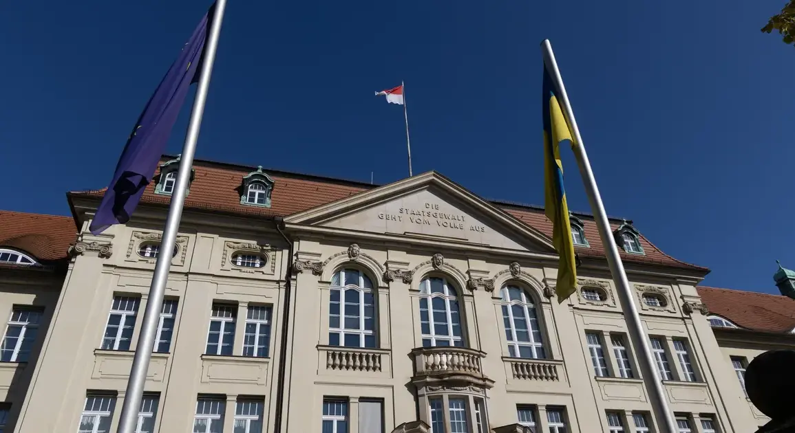 Historisches Regierungsgebäude mit Inschrift „Die Staatsgewalt geht vom Volke aus“, davor EU-, Ukraine- und Brandenburg-Flagge