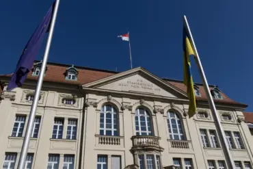 Historisches Regierungsgebäude mit Inschrift „Die Staatsgewalt geht vom Volke aus“, davor EU-, Ukraine- und Brandenburg-Flagge