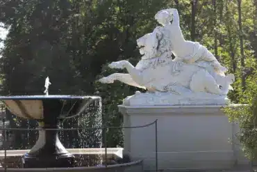Marmorskulptur einer Frau auf einem Löwen neben einem Springbrunnen