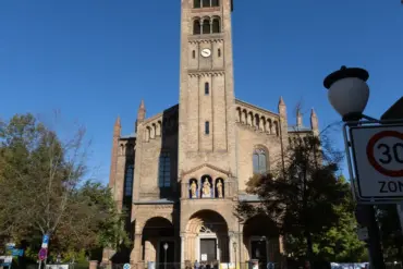 Katholische Kirche St. Peter und Paul mit Glockenturm, davor ein Tempo-30-Zonen-Schild