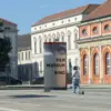 Stele „Filmmuseum Kino“ vor dem Marstall, daneben eine Haltestelle