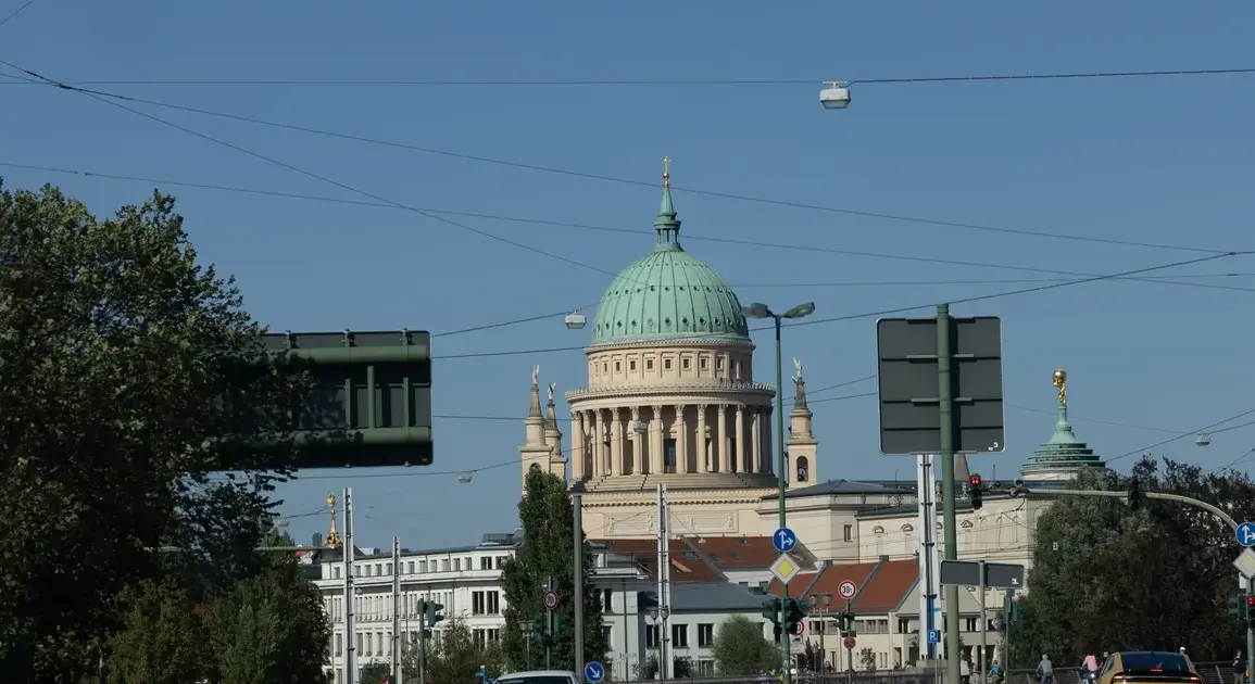 Blick über eine Hauptstraße auf die Kuppel der Nikolaikirche